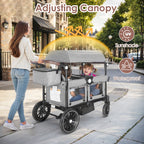 Woman pushing a large, multi-seater wagon with canopy on a sidewalk.