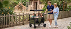 Family with children in a stroller at a zoo, with giraffes in the background.